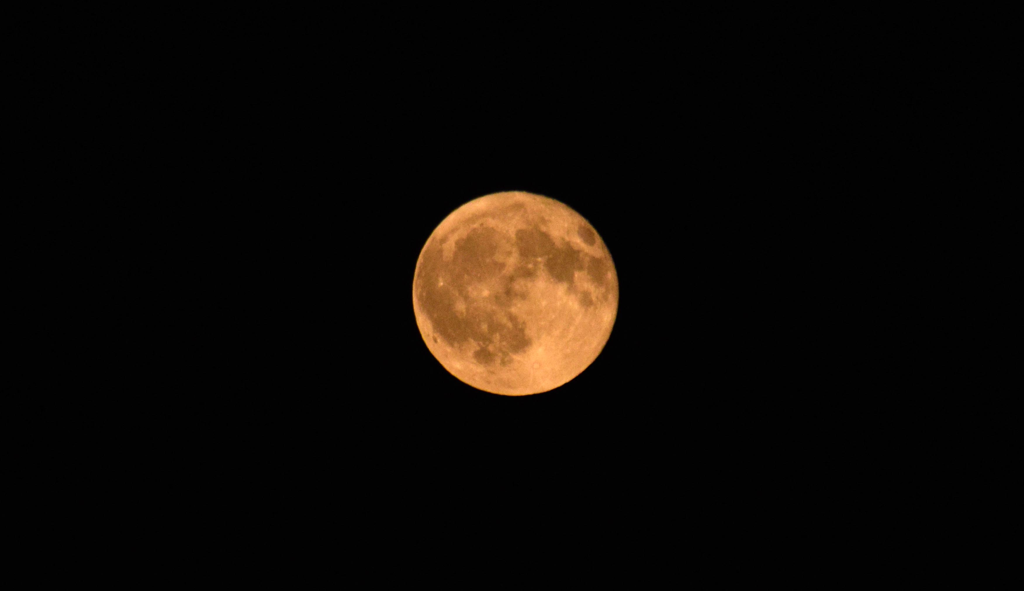 Fotografia di una Luna piena arancione.